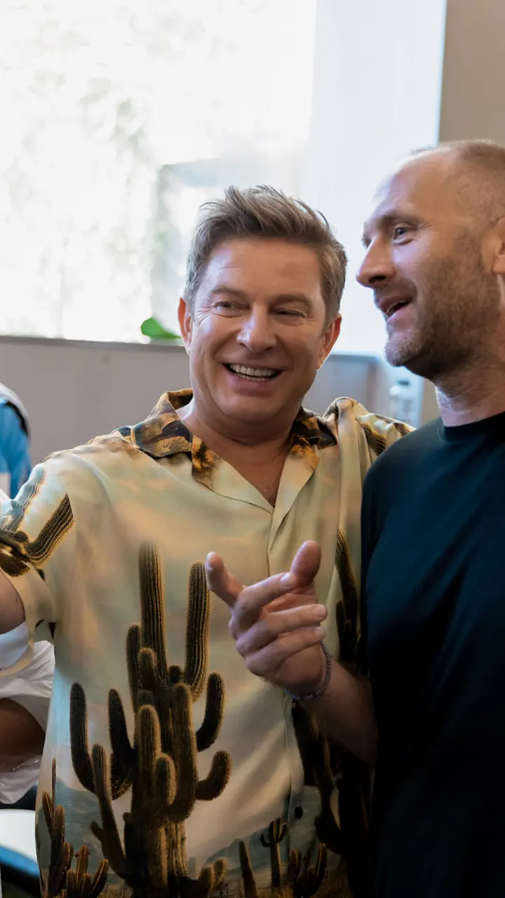 Pavel Bartoș râzând cu un membru al echipei, între duble