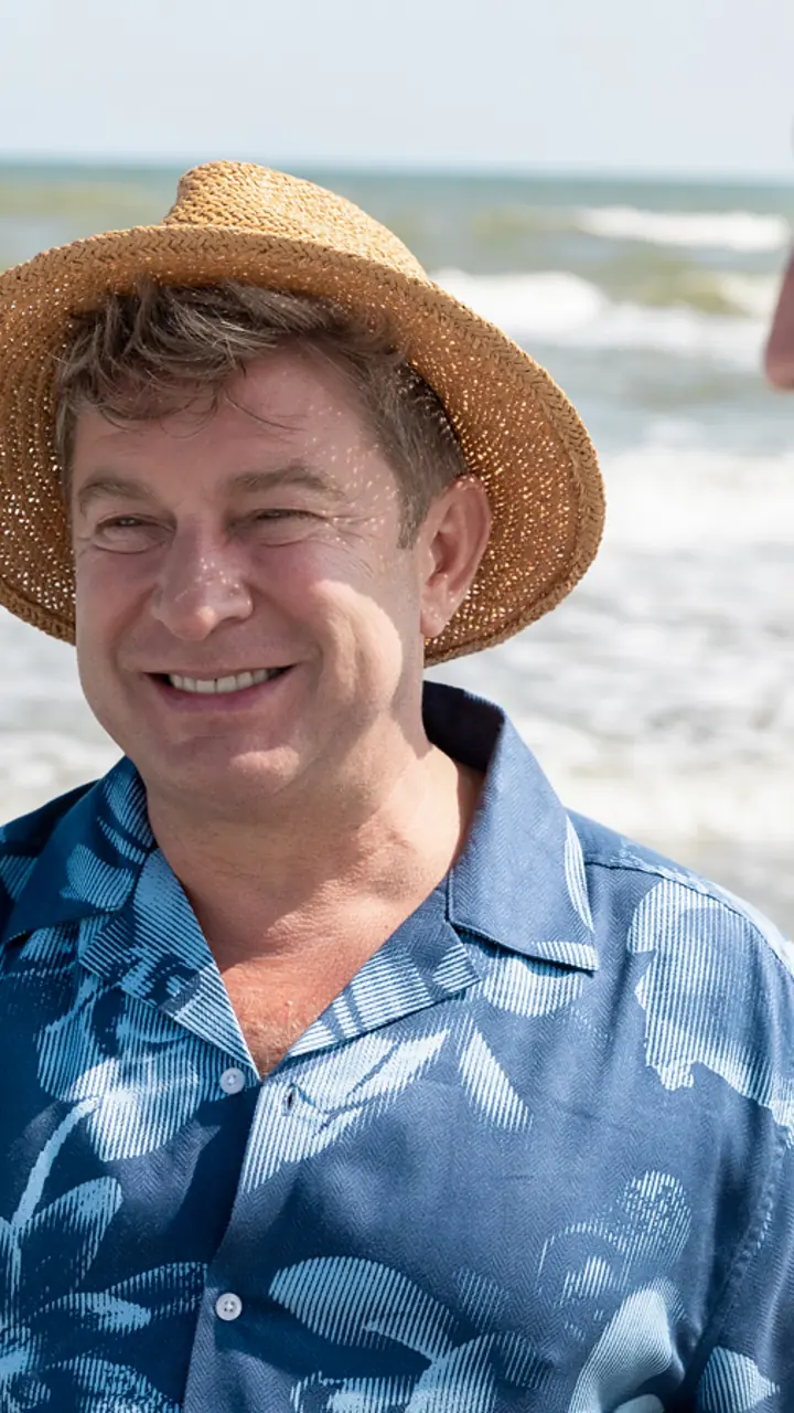 Pavel Bartoș cu pălărie de paie, pe plajă